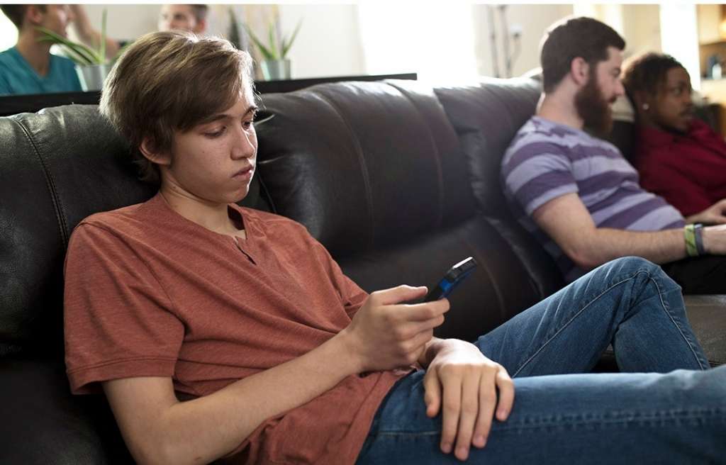 Young male adults hanging out on a couch at Rockville Sober Living house