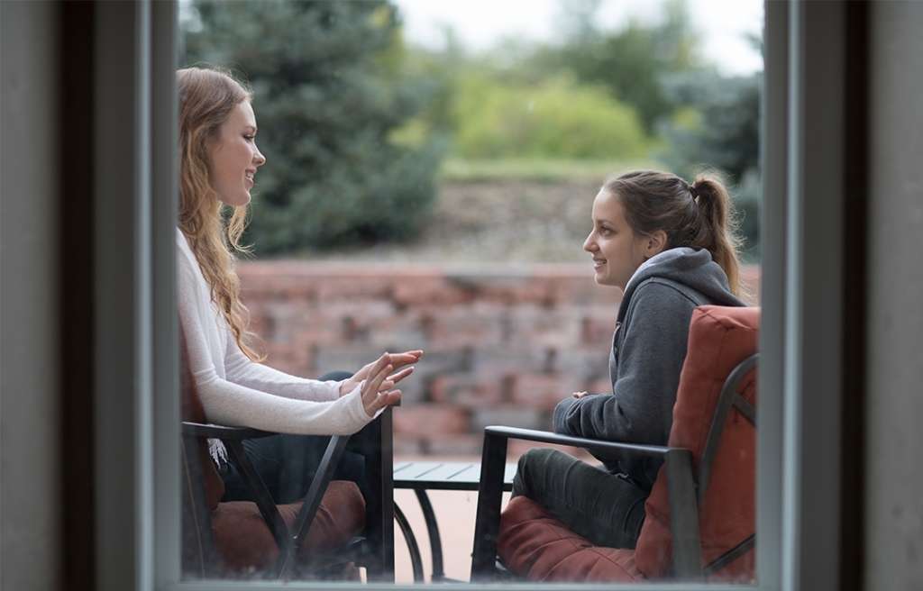 2 young female adults talking outside Rally Point Boulder Treatment Center