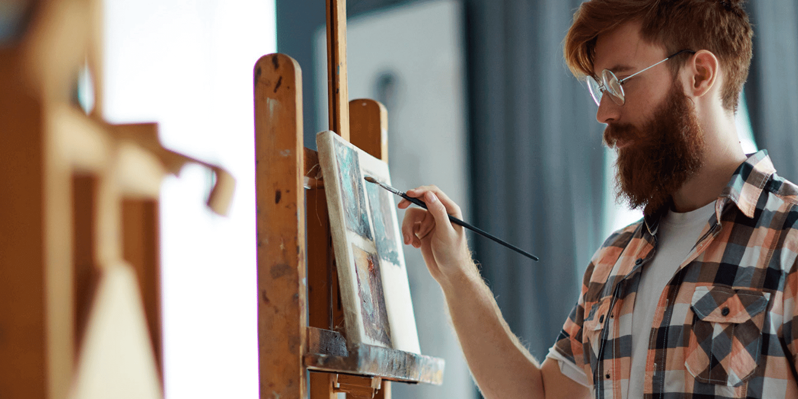 A young man painting on canvas