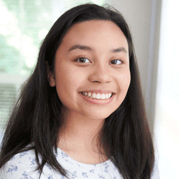 there is a young woman smiling and holding a toothbrush