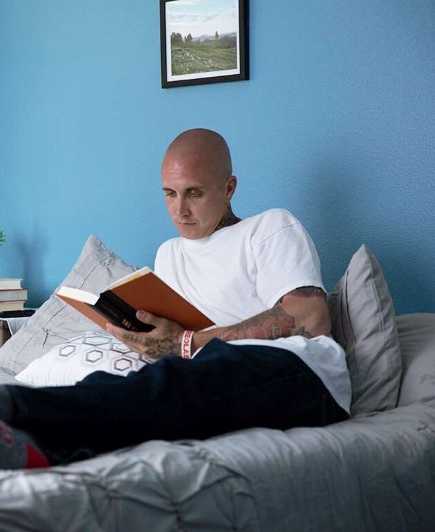 Client reading in his bed at Colorado Springs detox center bedroom
