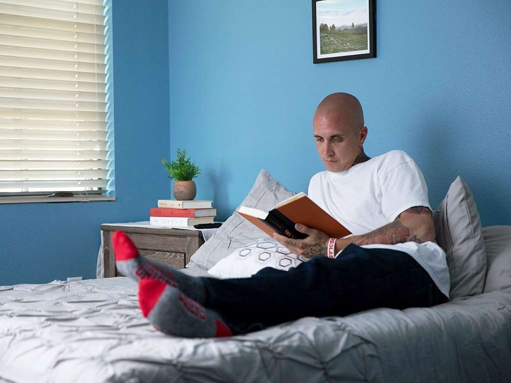 Client reading in his bed at Colorado Springs detox center bedroom