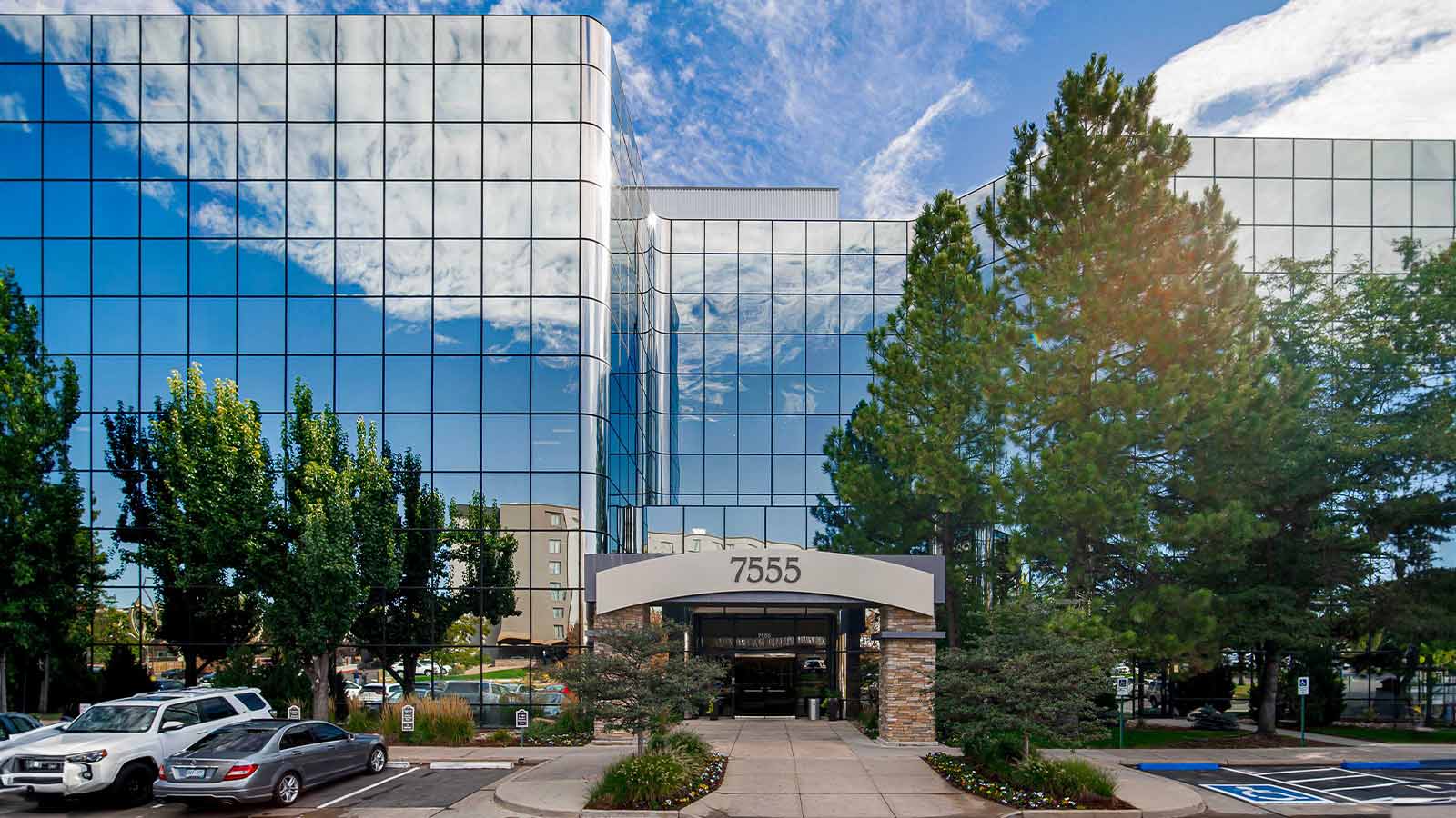 A reflective glass modern building under a clear sky.