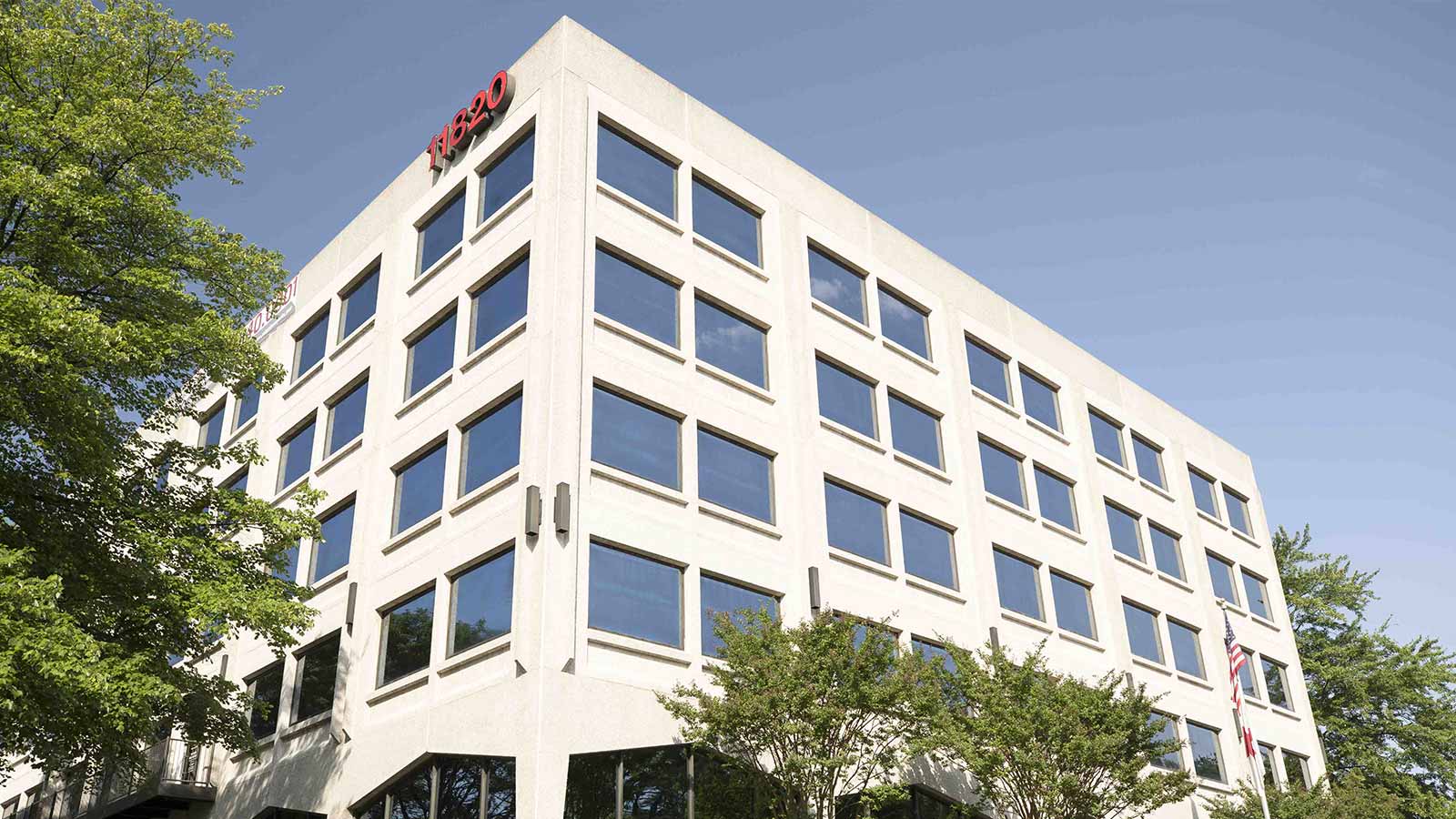 A low-angle view of a modern office building under a clear sky.