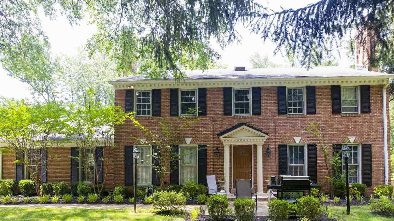 A traditional two-story brick house with shutters.