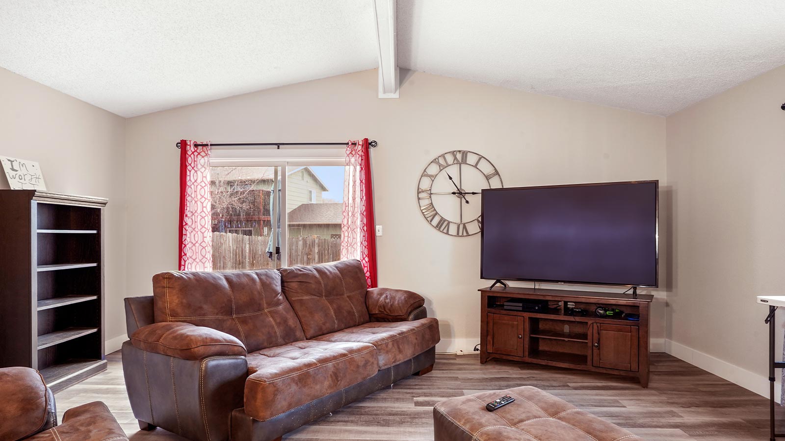 A cozy living room with a large brown leather sofa.