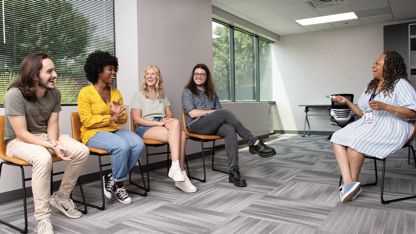 several people sitting in a waiting room talking to each other