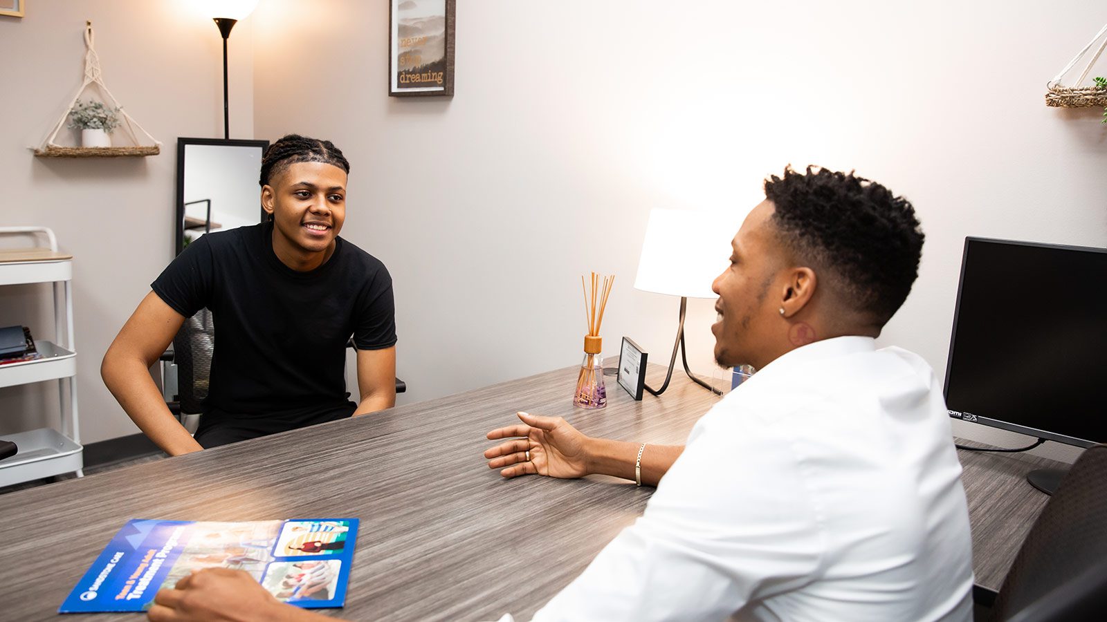 Two male individuals in a one on one counseling session.