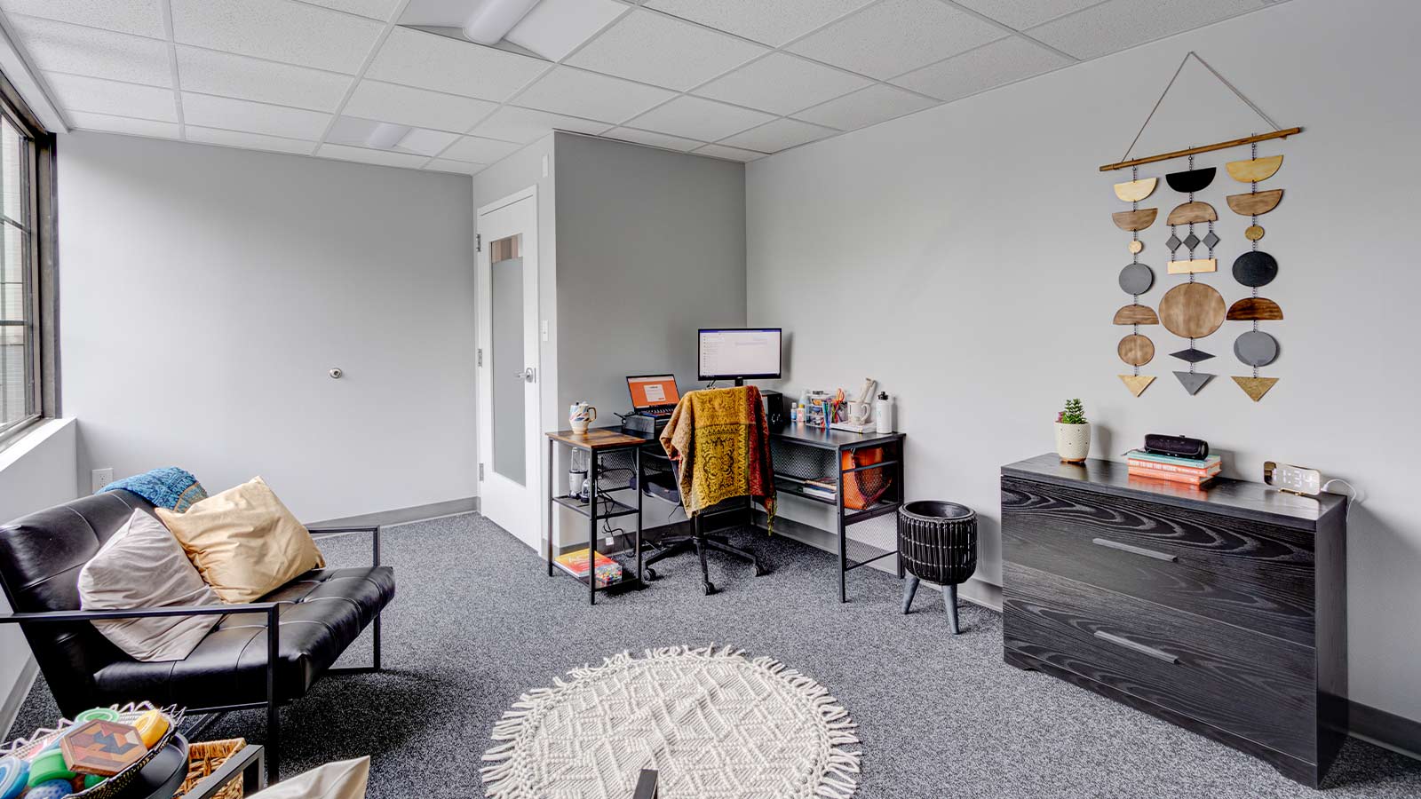 there is a room with a chair, a dresser, and a window