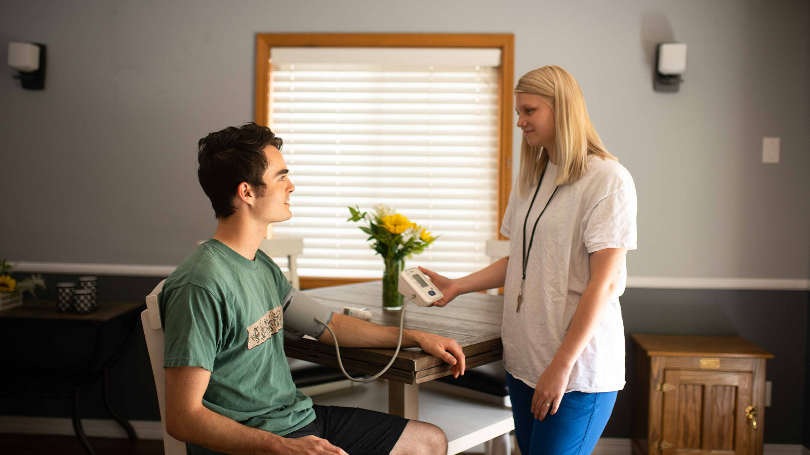 A young man having his blood pressure measured by a healthcare professional.