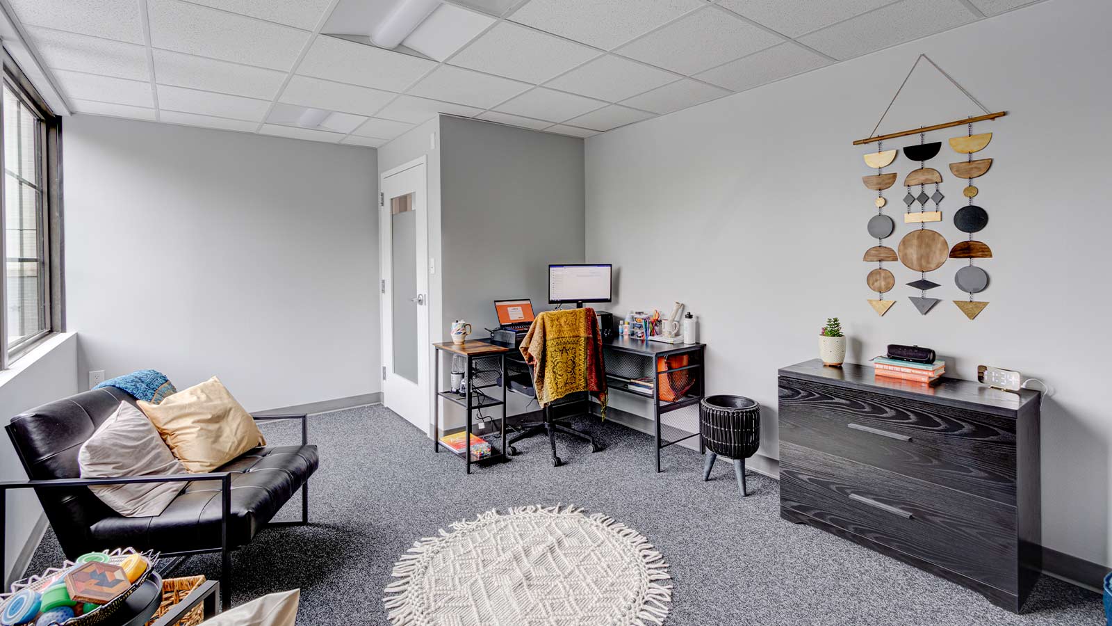A cozy office space with warm colors and multiple seating options.