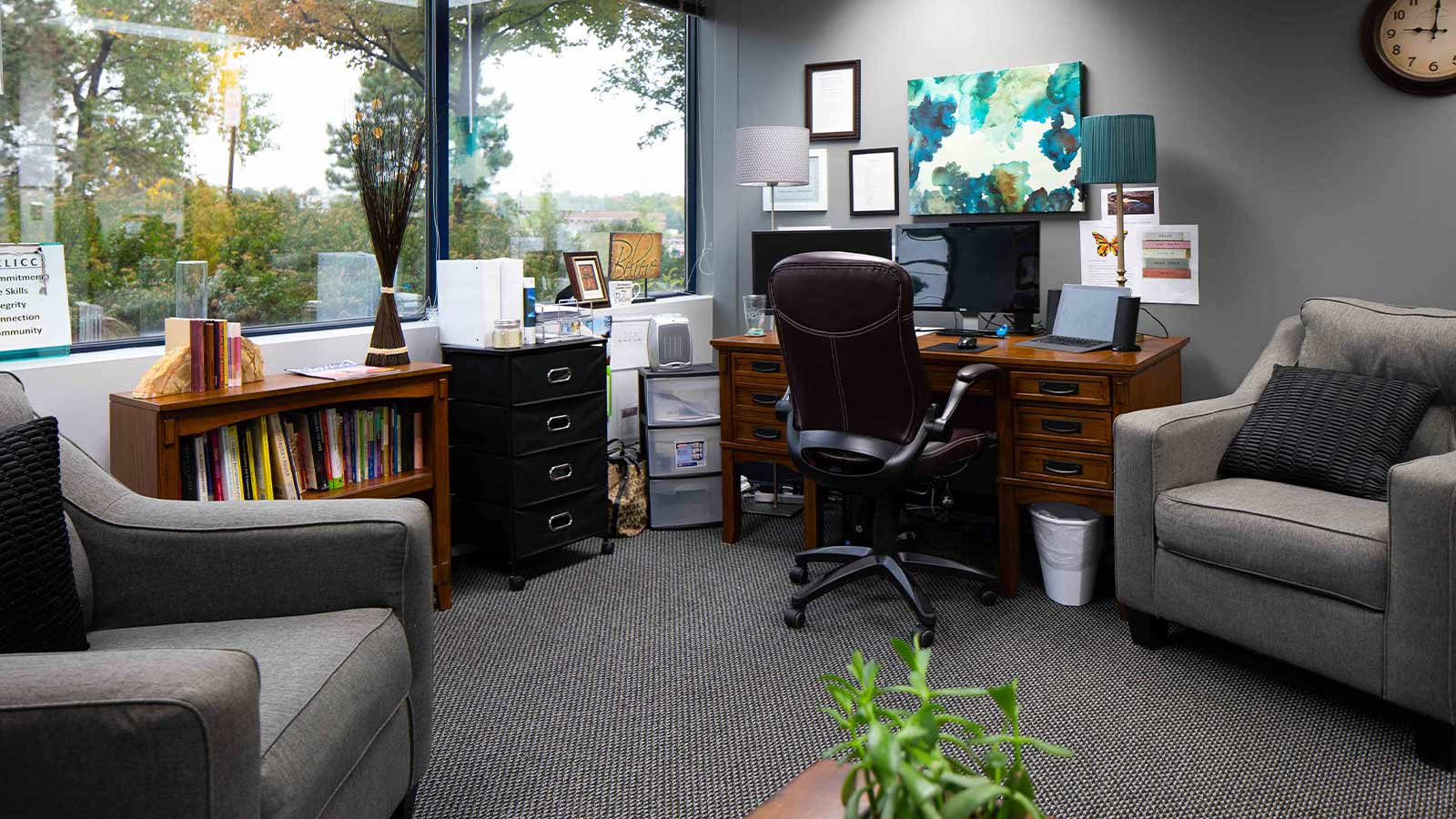 Cozy office environment with bookshelf, comfortable seating, and a warm decorative style.