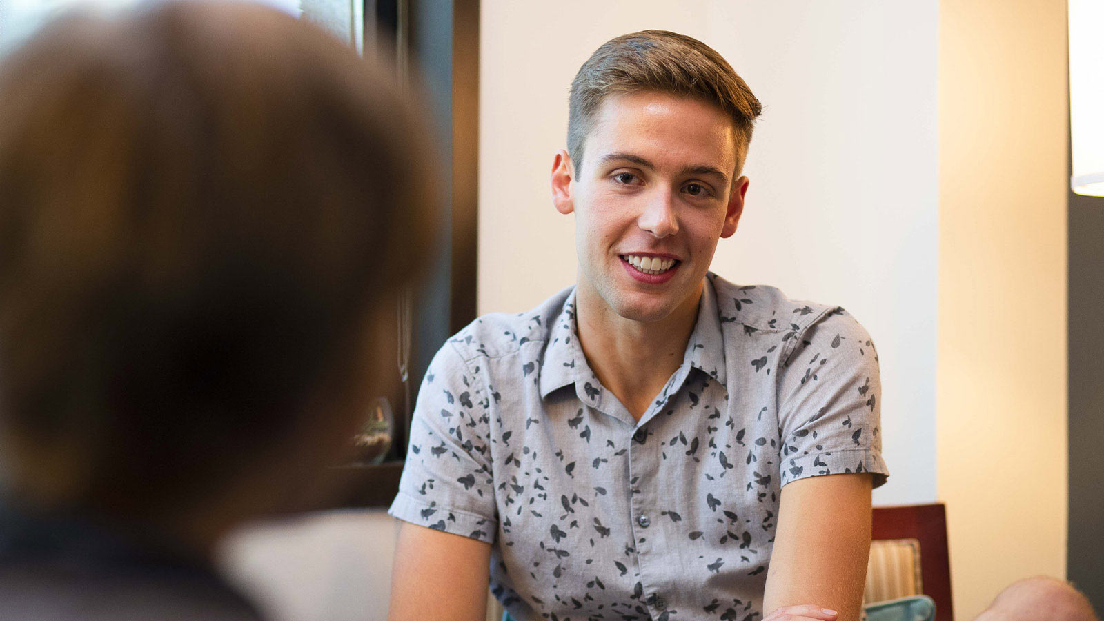 A young man in a smiling and talking.