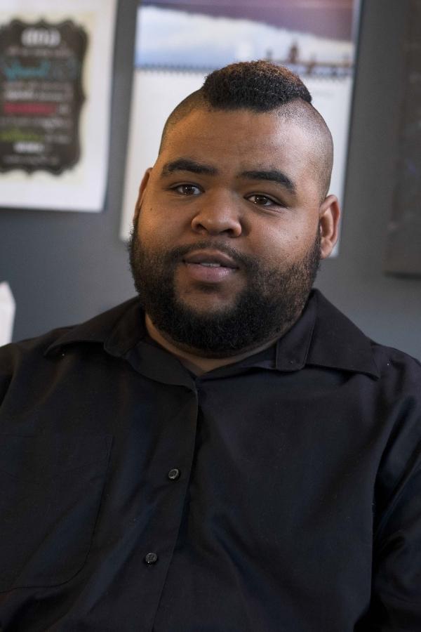 A black man sitting in a transitional living home.