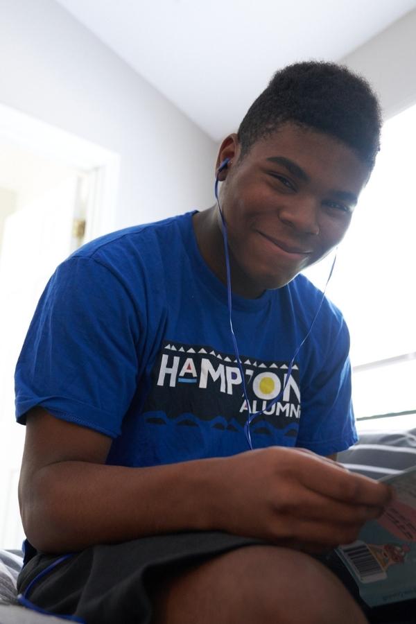 Teenager smiling in a bedroom of a residential rehab center