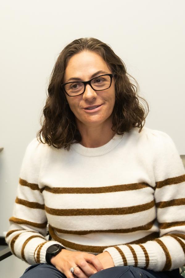 A brunette clinician with glasses speaking.