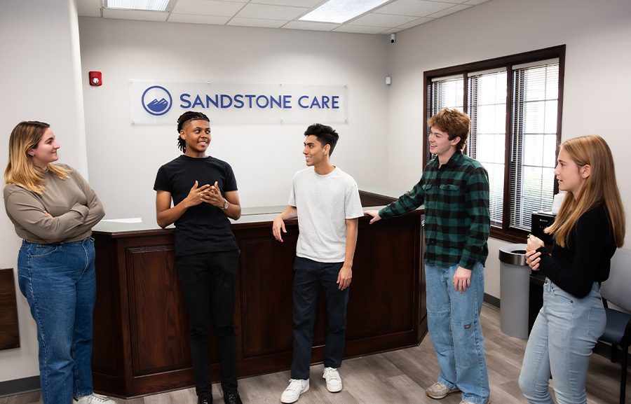 group of teens chatting in waiting room of outpatient rehab center