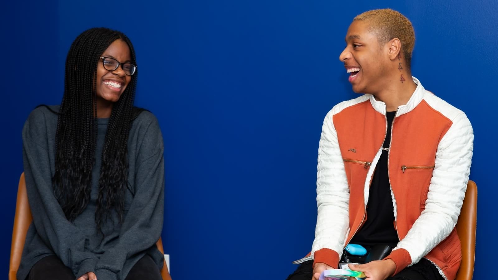 two teens laughing while in group therapy session