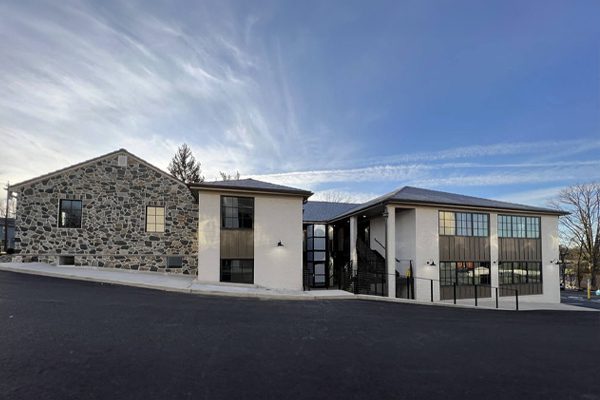 A contemporary building with a stone facade and large windows against a blue sky