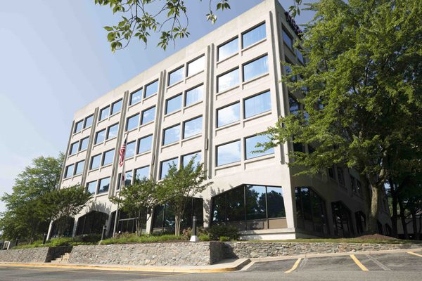 Sanstone Care's Mental Health Center in Rockville, Maryland. A stone building with lots of greenery surrounding the building.