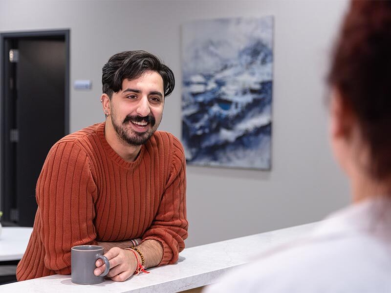 there is a man sitting at a counter with a cup of coffee