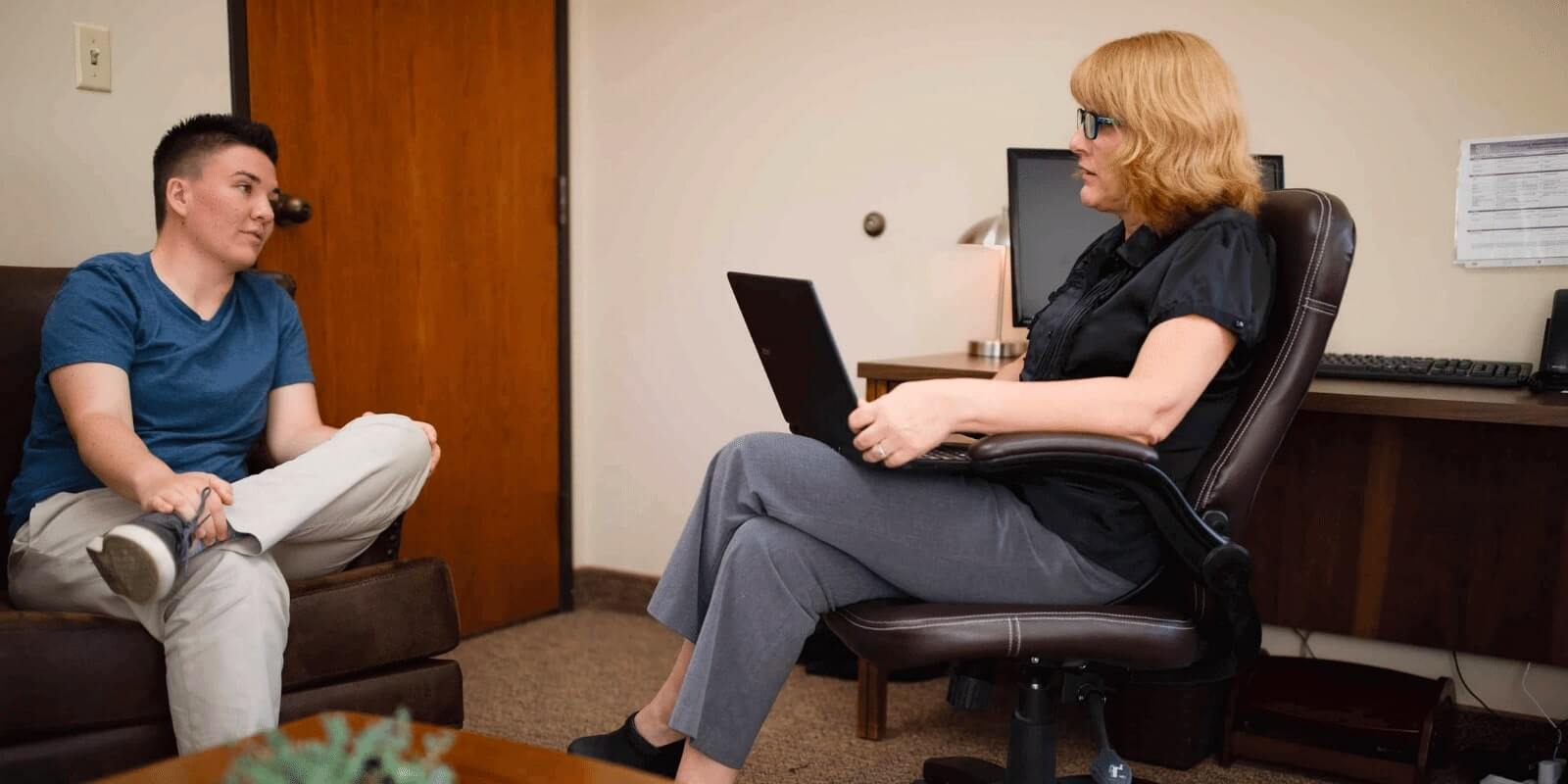 Young adult talking to a therapist in a room