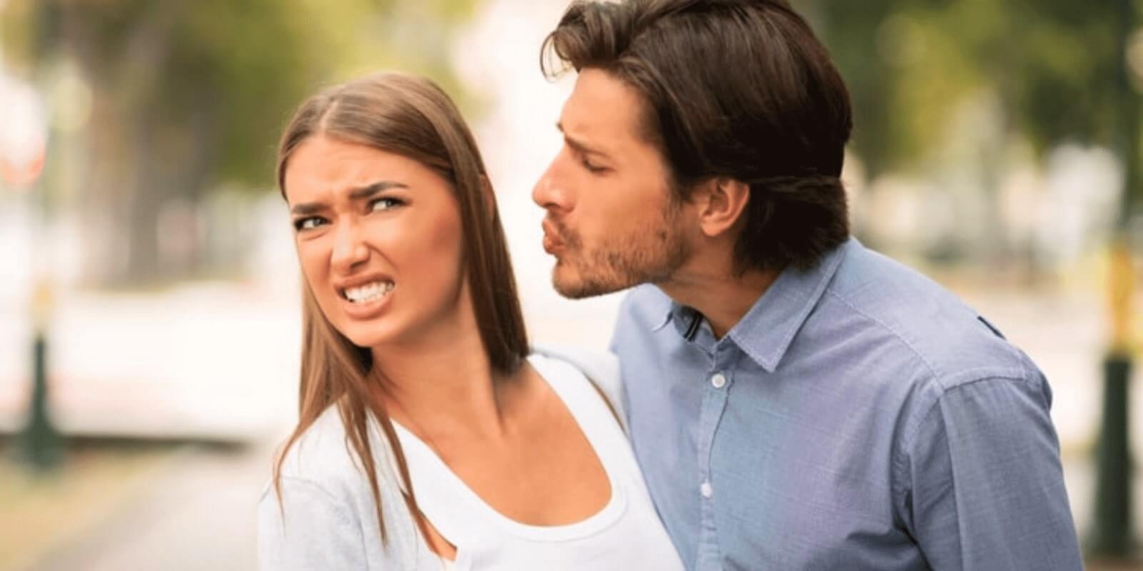 A woman looking disgusted when her partner tries to kiss her