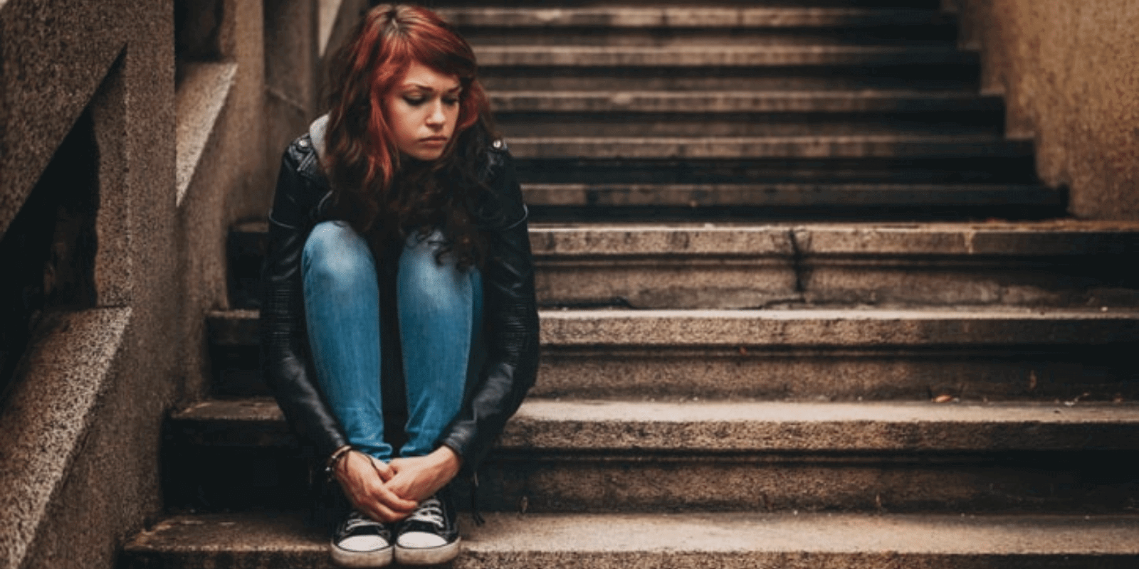 A teen looking down on a staircase