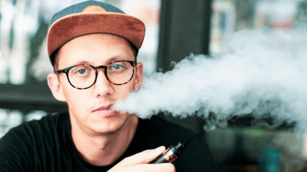 there is a man smoking a cigarette with a hat on