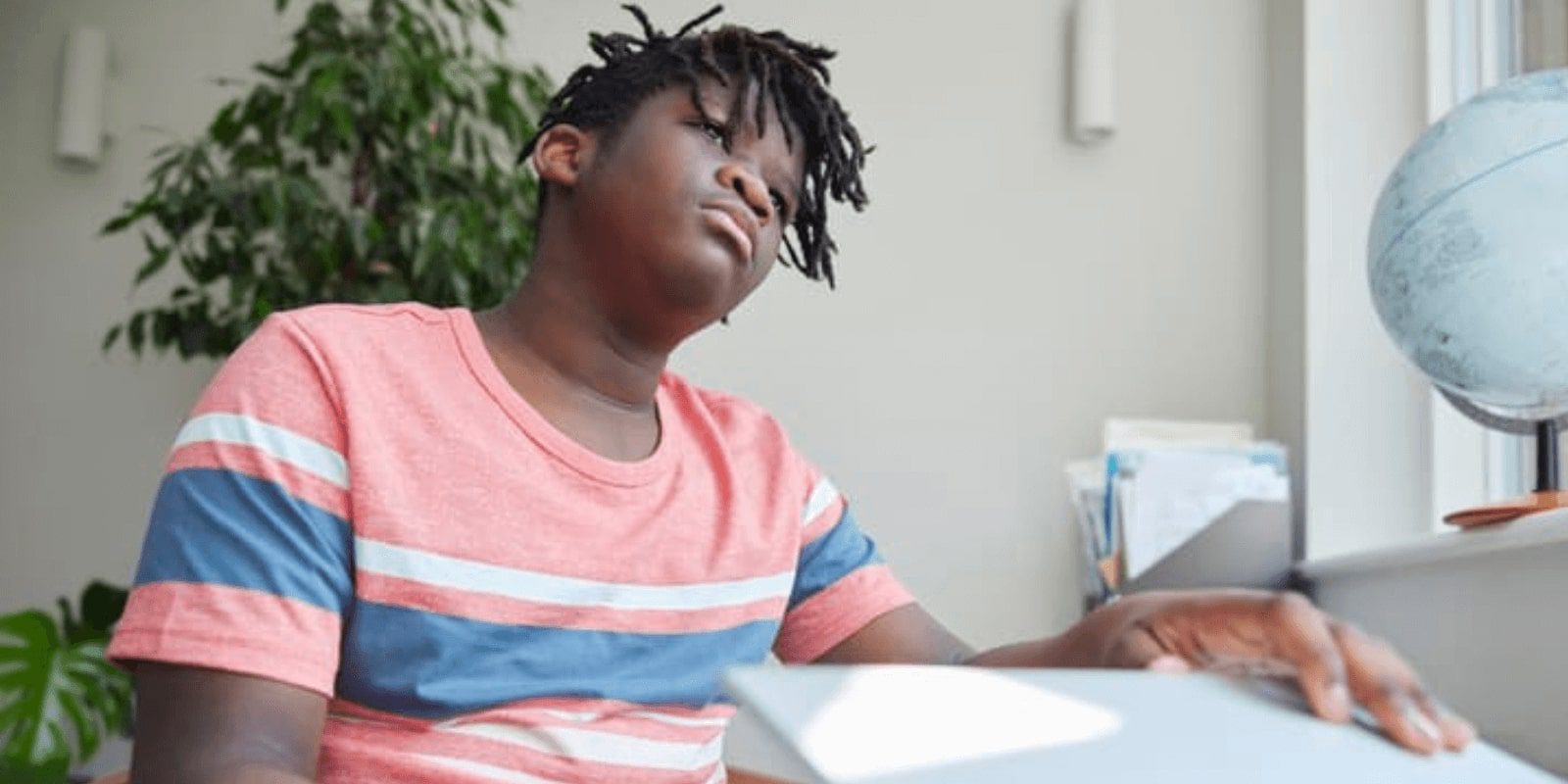 kid sitting at desk closing laptop