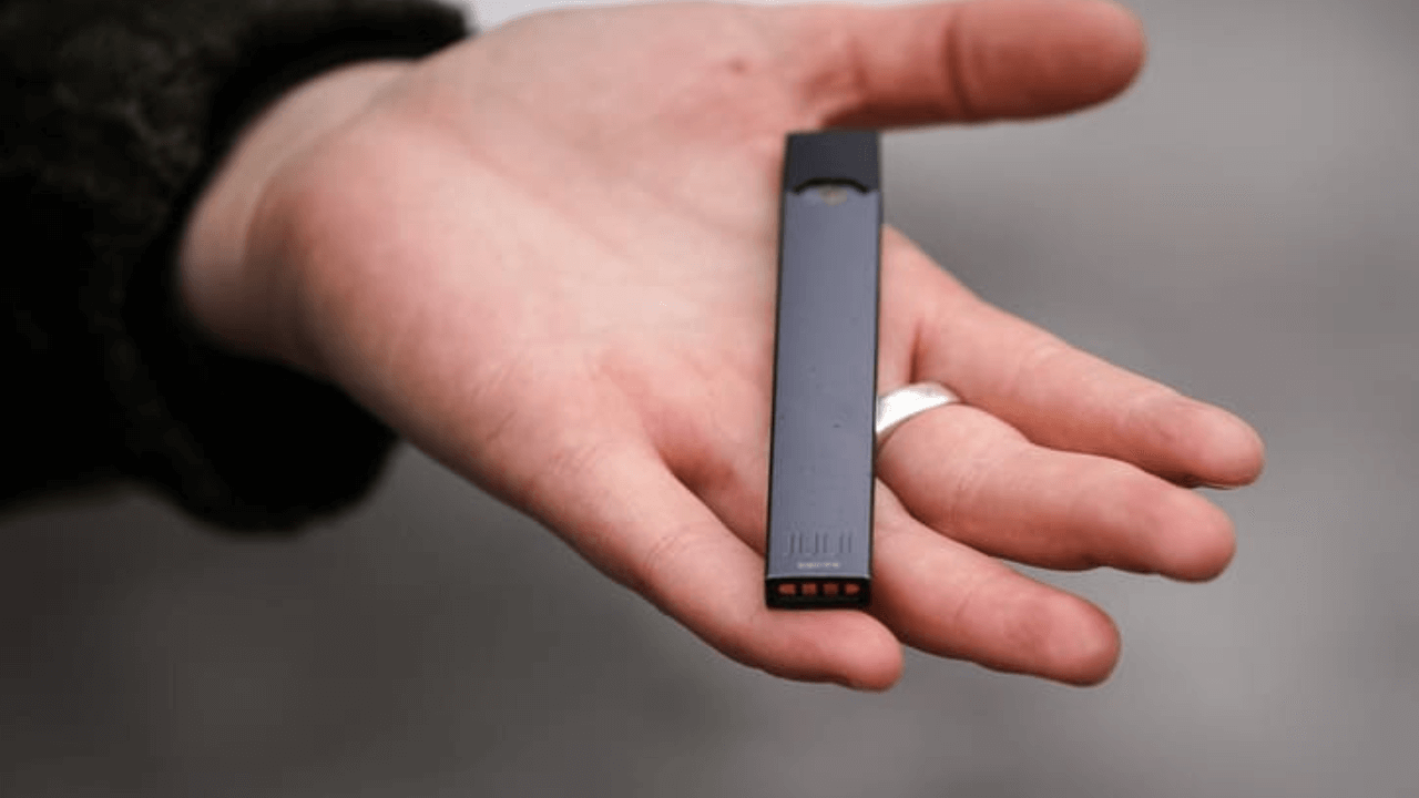 someone holding a cell phone in their hand with a small object in the palm