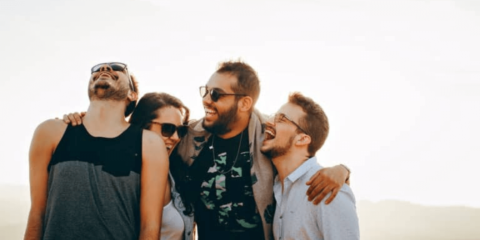 A group of young adults putting arms around each other cheering