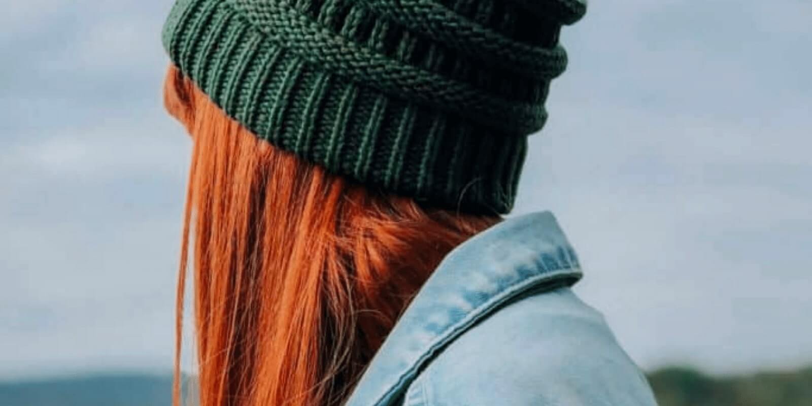 A girl wearing a green beanie looking behind