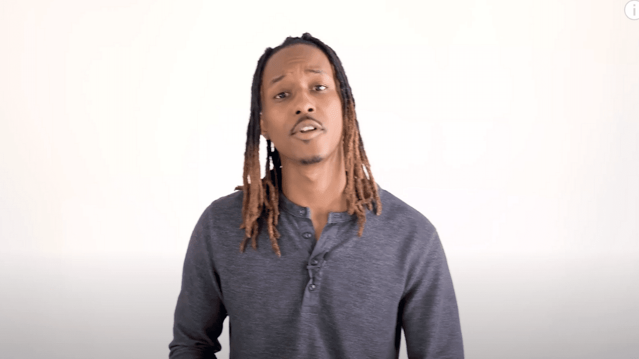 An African American talking to the camera on a white background