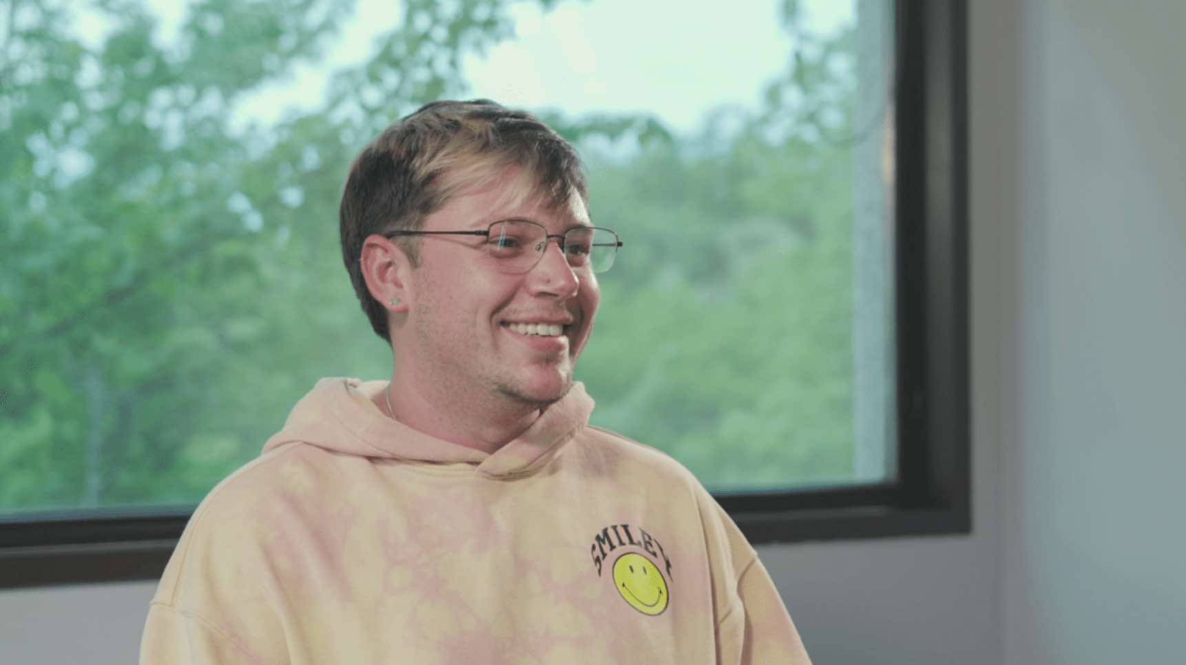 A young man, Robert, smiles at the interviewer.