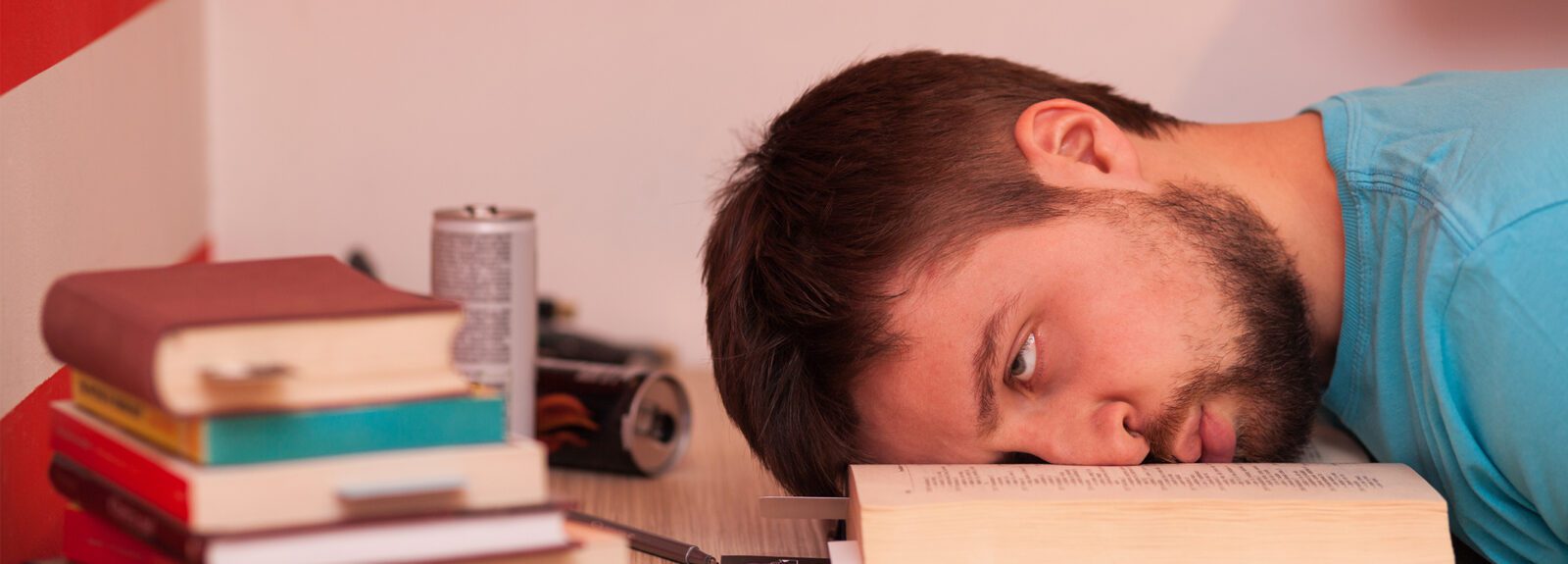 male college student studying, drinking energy drinks