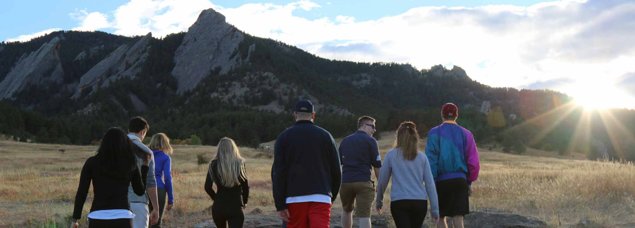 Group of Young Adults Walking Toward Flatirons