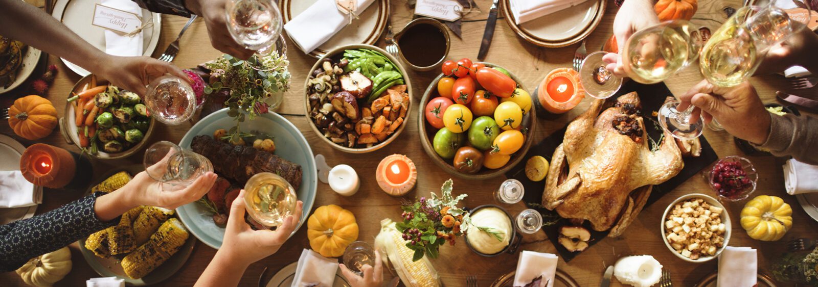 A thanksgiving table spread with tons of food and drink.
