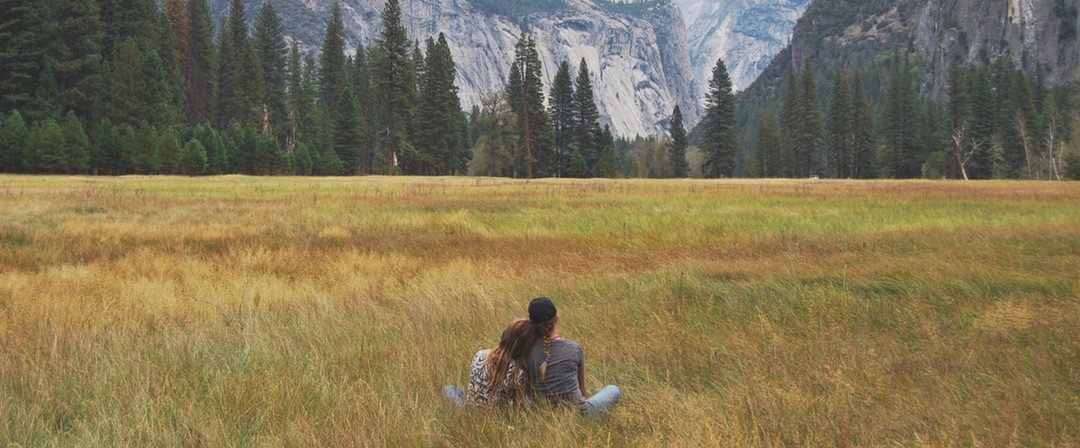 friends in open field, mountain backdrop