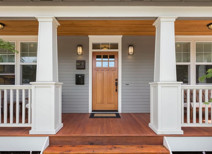 a close up of a front porch with a wooden door and steps