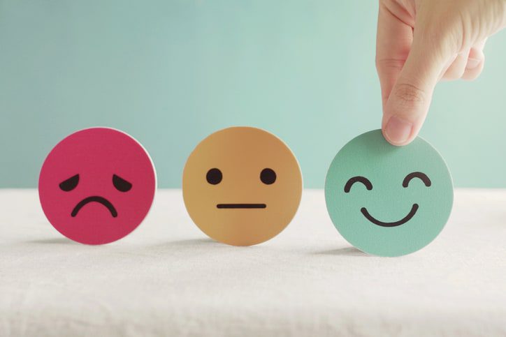 Hand choosing green happy smiley face paper cut, product, user, service feedback rating and customer reveiw, experience, satisfaction survey, psychology mental health test concept