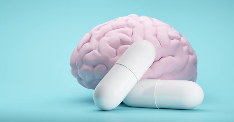 White Pills on blue background with brain model