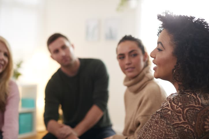 Woman Speaking At Support Group Meeting For Mental Health Or Dependency Issues In Community Space