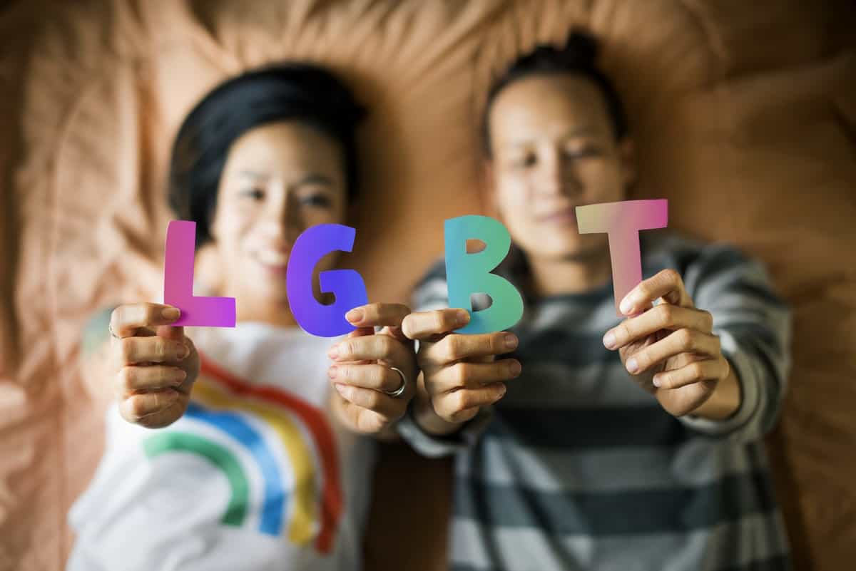 lgbtqia-youth-laying-on-bed-holding-letters
