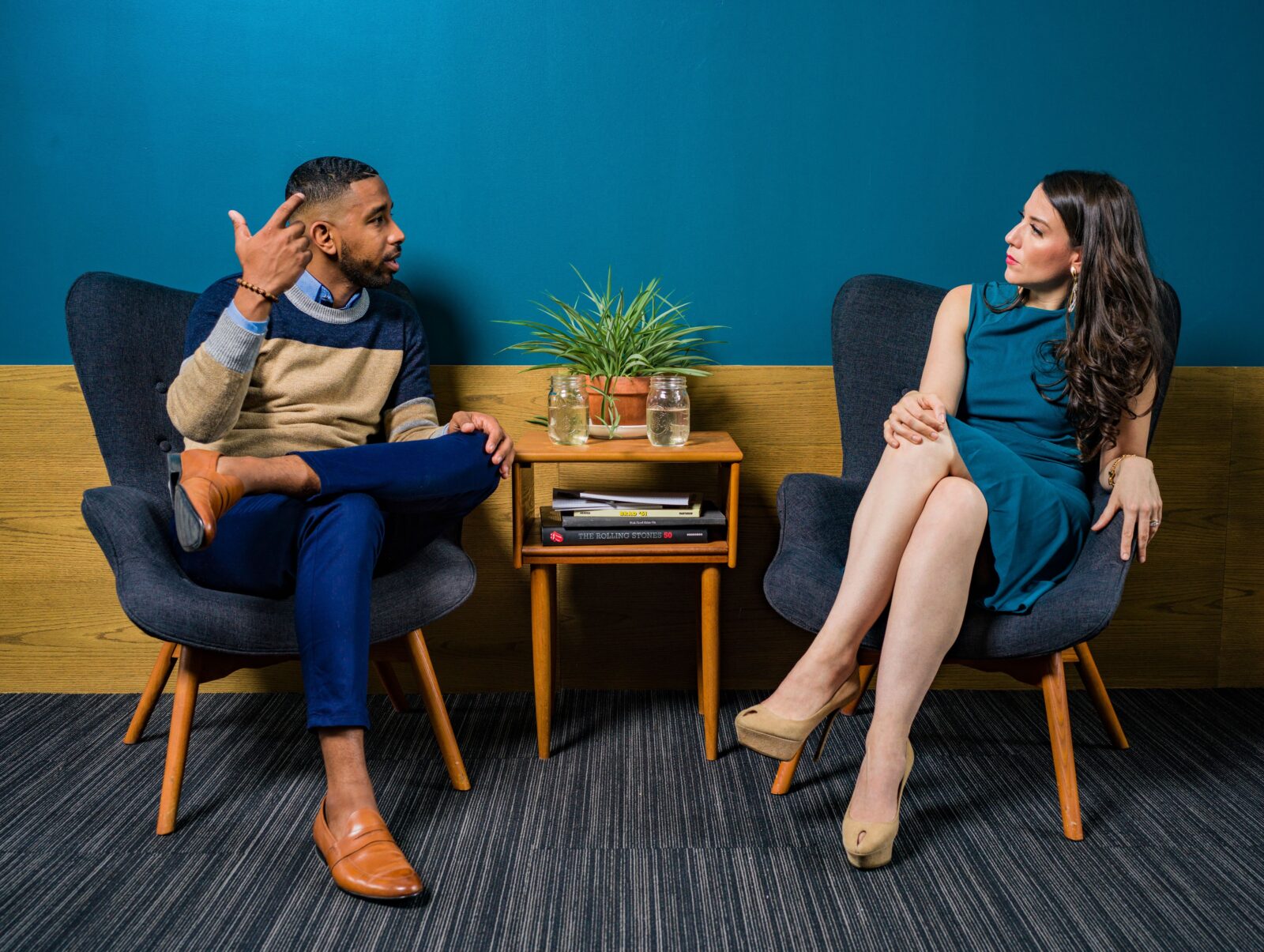 there are two people sitting in chairs talking to each other