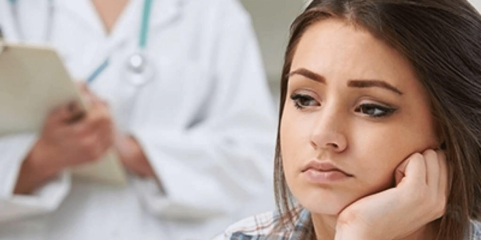 A teen looking concerned in front of a doctor