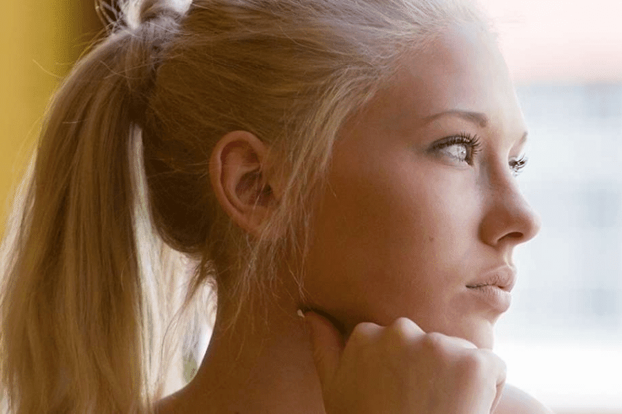 A teen girl looking away over the window in the right concerned