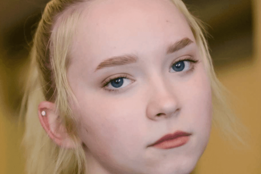 A teen girl making eye contact with the camera lens