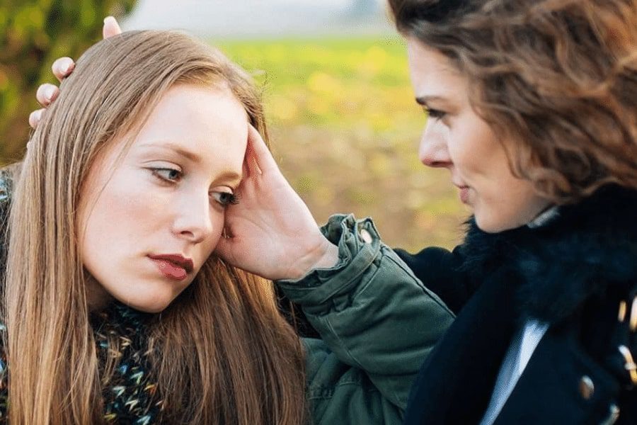 A woman checking if her daughter is feeling ok