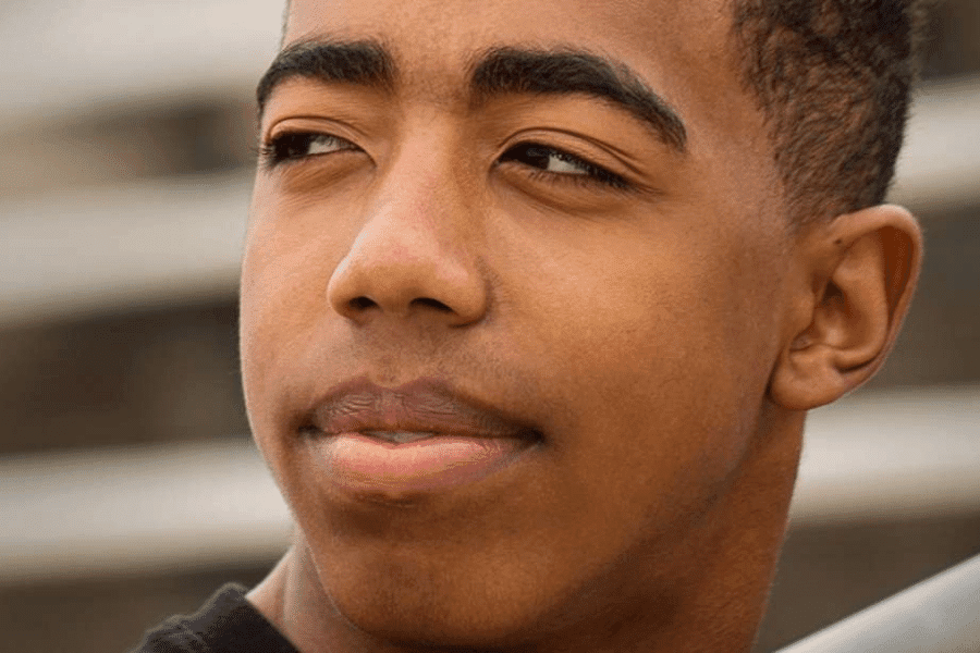 A young man looking away with his eyes squinted